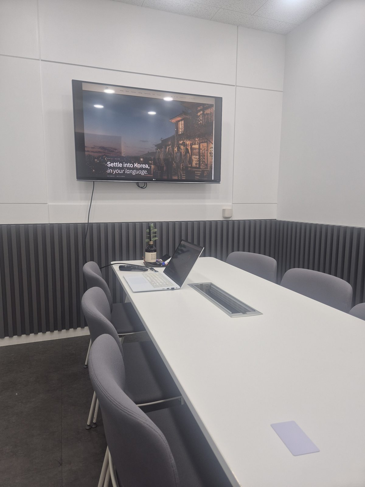 English UniHome page displayed on a meeting-room screen